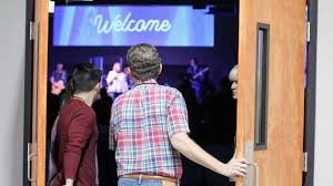 A boy welcoming people to church